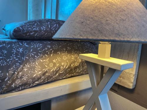 a lamp on a table next to a bed at Cascina Spazio Indaco in Castagnole Monferrato