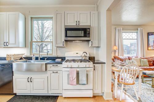 a kitchen with white cabinets and a stove top oven at Lovely Elkhart Lake Apartment - Walk to Town! in Elkhart Lake