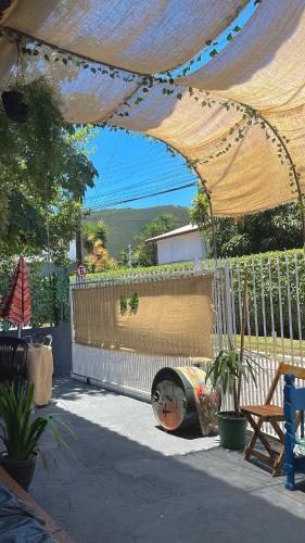 Off hostel floripa في فلوريانوبوليس: فناء به سياج وخيمة بها نباتات