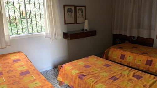 een kamer met 2 bedden en een raam bij Casa Itaguá in Ubatuba