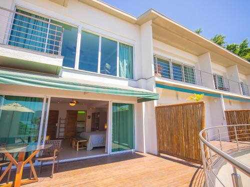 a house with a deck with a table and chairs at Hotel Velas do Engenho in Ilhabela
