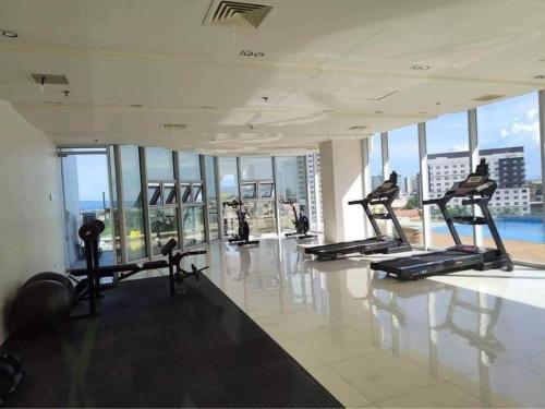 een fitnessruimte met cardio-apparatuur in een gebouw met ramen bij 10F Central location & Near Airport in Davao City