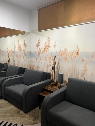 a living room with couches and a painting on the wall at Apartamenty Terminal Charzykowy in Charzykowy