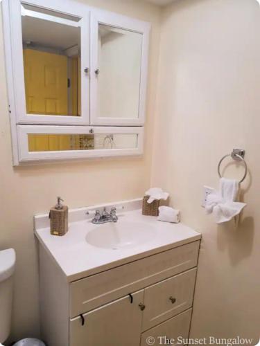 a bathroom with a sink and a mirror at The Sunset Bungalow in Naples