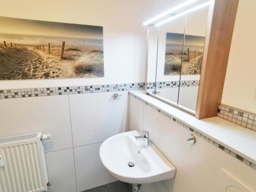 a bathroom with a sink and a mirror at Apartmentvermittlung Mehr als Meer - Objekt 46 in Niendorf