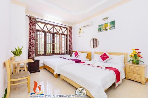 una camera d'albergo con due letti e una finestra di VILLAGES ĐĂNG KHOA CÔNG VIÊN BÃI SAU Vũng Tàu Xanh a Vung Tau