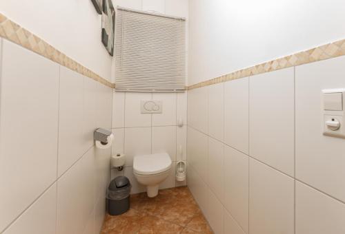 uma casa de banho branca com um WC e uma janela em Ferienwohnung Ulli by Schladming-Appartements em Schladming