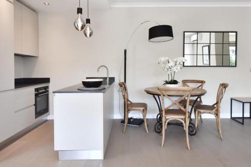 une cuisine avec une table et des chaises dans une pièce dans l'établissement CANNES - 2-BR flat 15-min walk to the beaches, à Cannes
