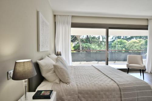 une chambre avec un lit et une grande fenêtre dans l'établissement CANNES - 2-BR flat 15-min walk to the beaches, à Cannes