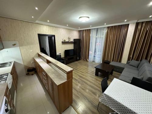 a large living room with a couch and a television at Comfortable House the city centr in Kutaisi