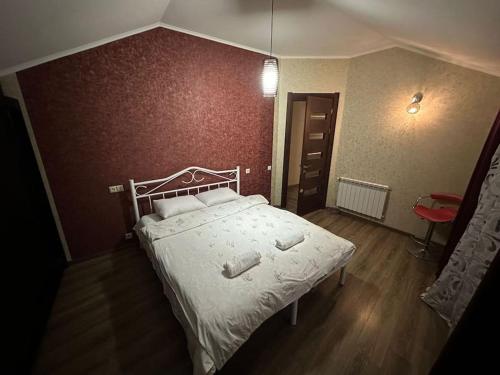 a bedroom with a white bed with a red wall at Comfortable House the city centr in Kutaisi