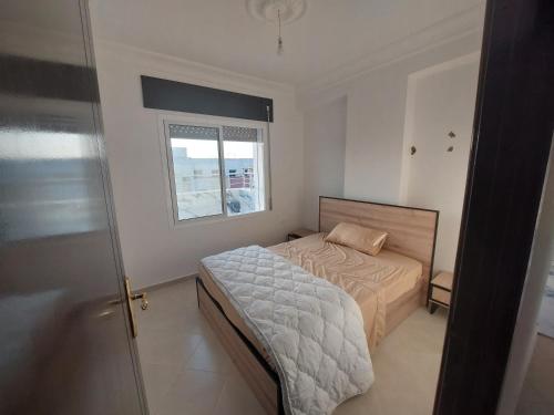 ein kleines Schlafzimmer mit einem Bett und einem Fenster in der Unterkunft Tanja balya 21 in Tangier