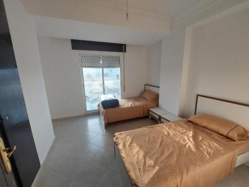 ein kleines Schlafzimmer mit 2 Betten und einem Fenster in der Unterkunft Tanja balya 21 in Tangier