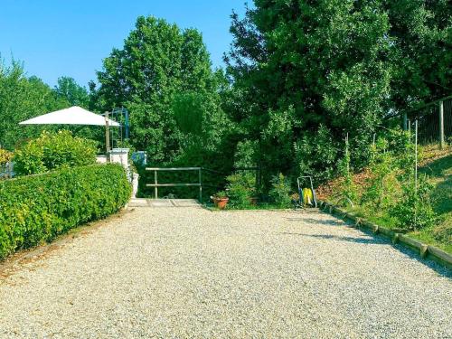 a gravel driveway with an umbrella in a garden at Cascina Spazio Indaco in Castagnole Monferrato