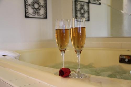 two glasses of champagne sitting on a bath tub at Hotel 620 in Hagerstown