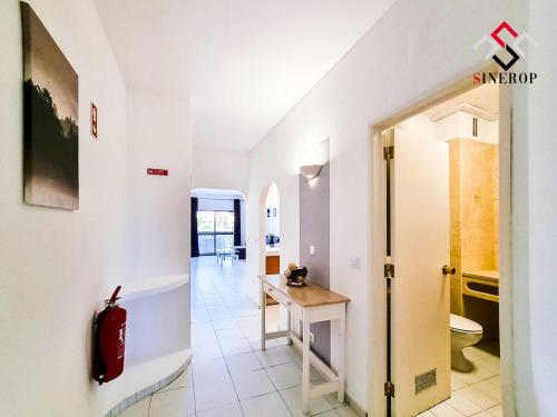 um corredor com um WC e uma mesa num quarto em Apartamento T1 - Valmangude em Albufeira