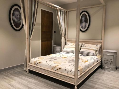 1 dormitorio con cama con dosel en una habitación en Charmes de la Forêt, en Huelgoat