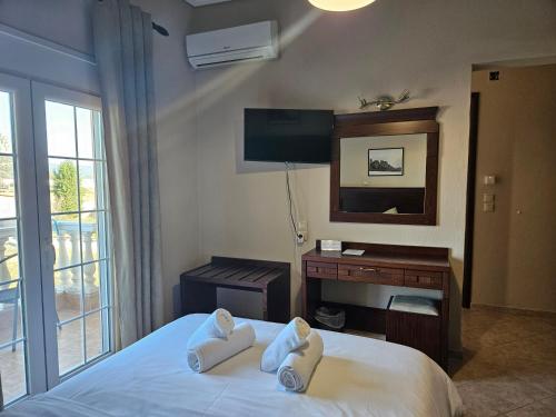 a bedroom with a bed with a desk and a mirror at Spilaio at Meteora in Kalabaka