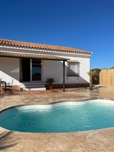 a swimming pool in front of a house at La Casita Rural in La Carlota