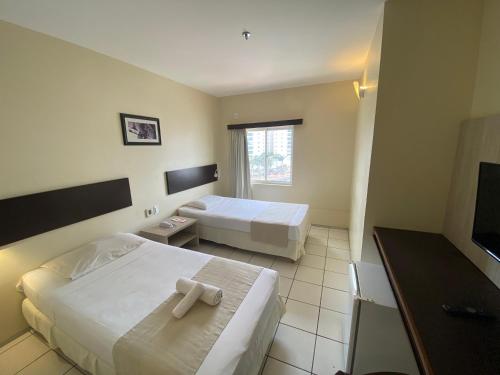 Cette chambre comprend deux lits et une télévision. dans l'établissement Hotel Premier, à São Luís
