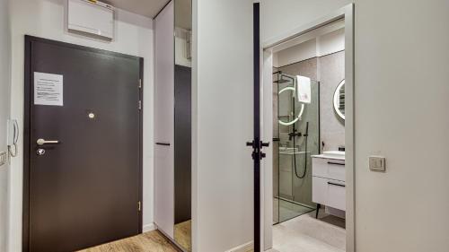 baño con puerta negra y lavamanos en Rezydencja Niechorze 213 - 5D Apartamenty, en Niechorze