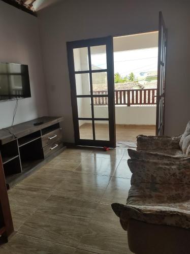 een woonkamer met een bank en een glazen schuifdeur bij Casa Mar Azul in Pitimbu