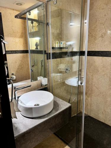 een badkamer met een wastafel en een glazen douche bij marron properties 14 in Caïro
