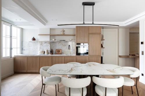 uma cozinha com uma mesa de jantar e cadeiras em HIGHSTAY - Luxury Serviced Apartments - Centre Pompidou em Paris