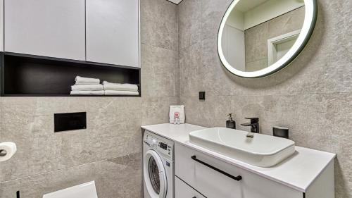 a bathroom with a sink and a washing machine at Rezydencja Niechorze 216 - 5D Apartamenty in Niechorze