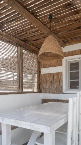 a white table and chairs in a room with windows at Cabana da Comporta in Comporta