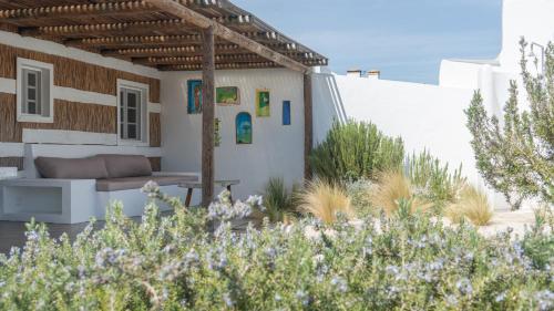 uma casa com um pátio com um sofá e algumas plantas em Cabana da Comporta na Comporta