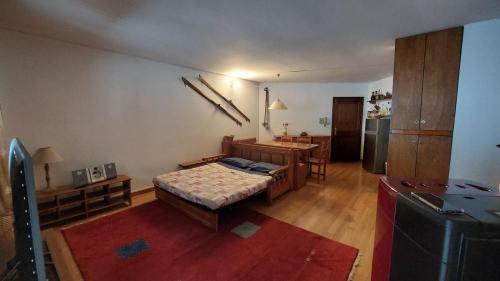 a room with a bed and a table and a kitchen at Sulle piste da Sergio&Lina in Pila