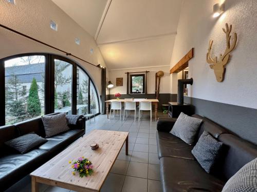 a living room with a couch and a table at Maison 25 in Houffalize
