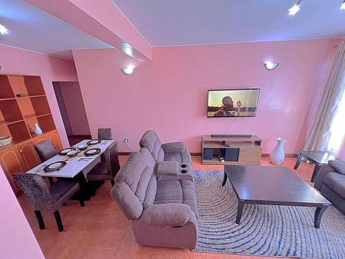 een woonkamer met een bank en een tafel bij Motema AirBnB in Kisumu