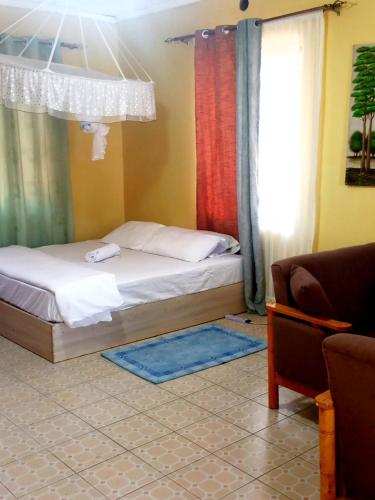 una camera con letto, finestra e divano di Motema AirBnB a Kisumu