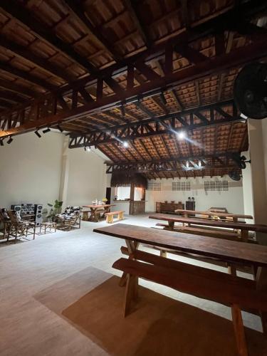 a large room with wooden tables and chairs at Pousada Dona Carmem Ubatuba in Ubatuba