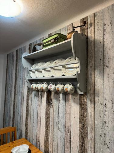 a wall with a bunch of dishes in a wine cellar at Apartmány Roudnice in Jestrabi V Krkonosich