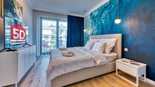 um quarto com uma cama grande e uma parede azul em Rezydencja Niechorze 209 z 2 sypialniami i 2 łazienkami przy plaży - 5D Apartamenty em Niechorze