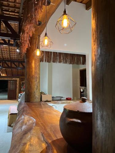 a room with a large wooden table and lights at Pousada Dona Carmem Ubatuba in Ubatuba