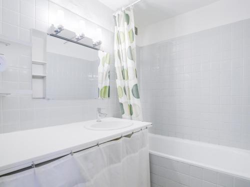 La salle de bains blanche est pourvue d'un lavabo et d'un miroir. dans l'établissement Appartement Les Arcs 1600, 3 pièces, 8 personnes - FR-1-411-351, à Arc 1600
