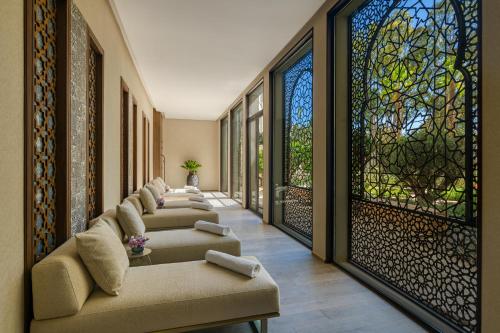 a row of chairs in a hallway with stained glass windows at Fairmont Tazi Palace Tangier in Tangier