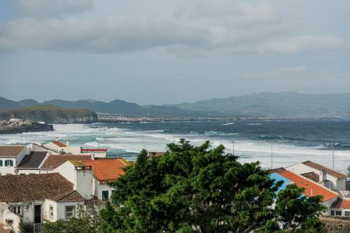 a view of the ocean from a town with houses at Azorean Ocean House - Terrace with Sea View in Ribeira Grande