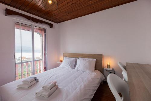 a bedroom with a large bed with towels on it at WelcomeBuddy - Azorean Ocean House in Ribeira Grande