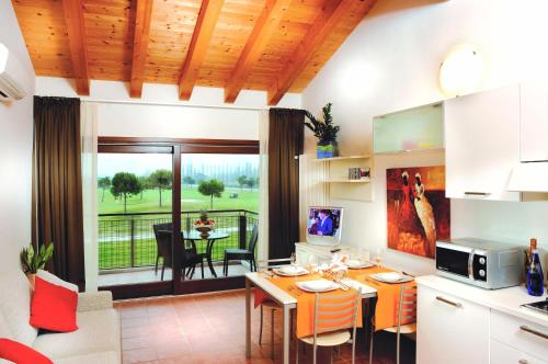 Il comprend une cuisine et un salon avec une table et des chaises. dans l'établissement Jesolo Living at Golf Club Jesolo, à Jesolo