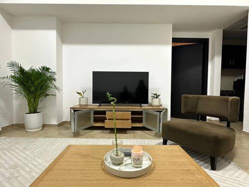 a living room with a table and a television at Lewish and stylish 1bhk at DSO in Dubai