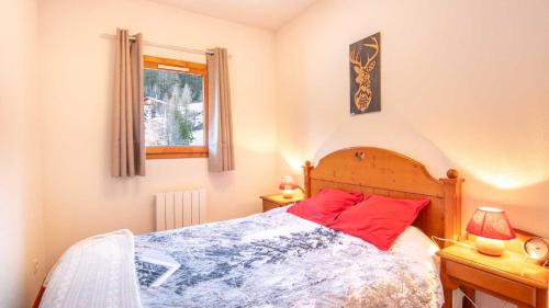 een slaapkamer met een bed met een rood kussen en een raam bij La Turra 407 - Appt familial 6 pers in Modane