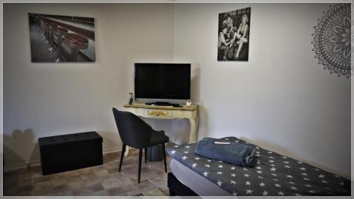 a room with a bed and a tv and a chair at Hannis Appartement in Erkelenz