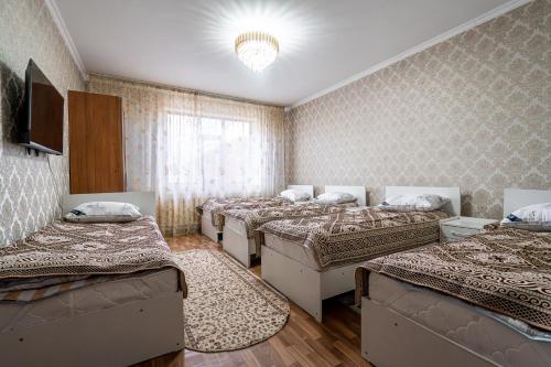 a room with four beds and a chandelier at Guest house "Halif" in Tegizchil