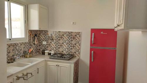 a kitchen with a red refrigerator and a sink at residence brini in Kairouan