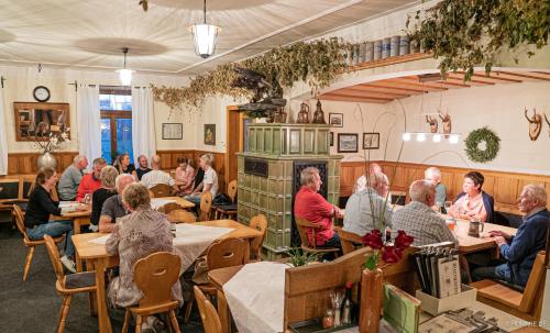 eine Gruppe von Personen, die in einem Restaurant an Tischen sitzen in der Unterkunft Brauereigasthof Adler in Oberstadion